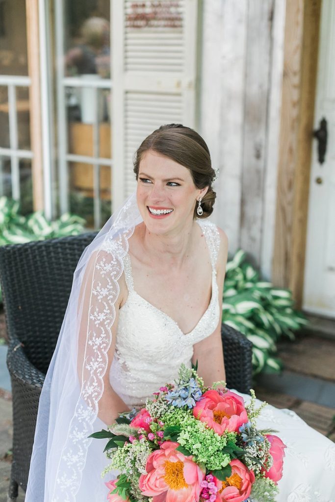 Bride poses with coral peony bouquet at Gillbrook Farms by the Jepsons