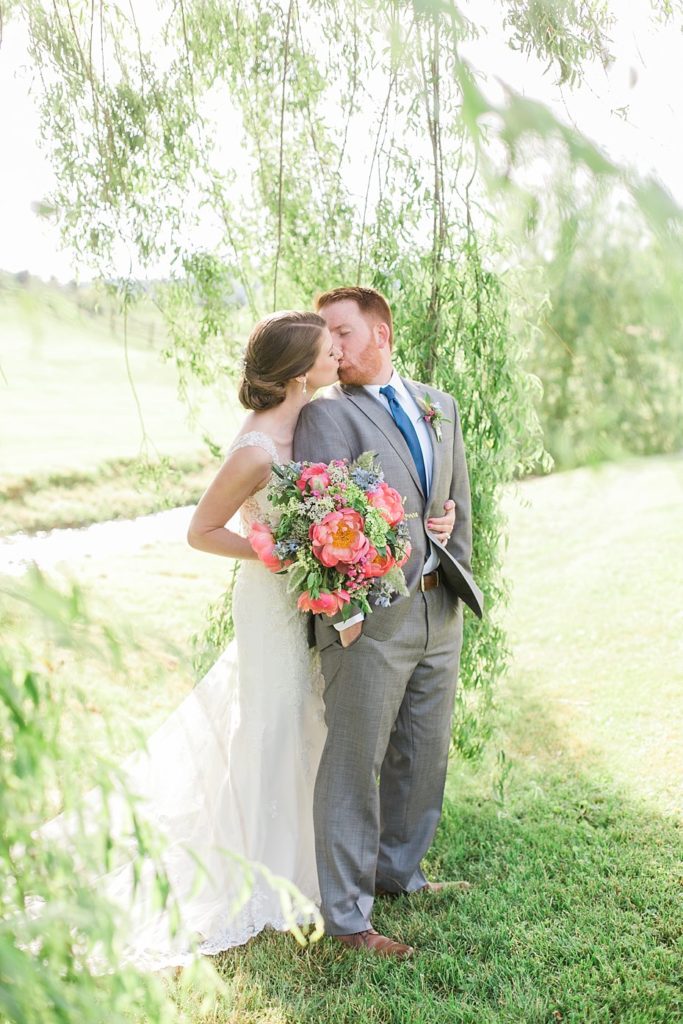 Bride and groom kiss under the willow tree at Gillbrook Farms in Central PA