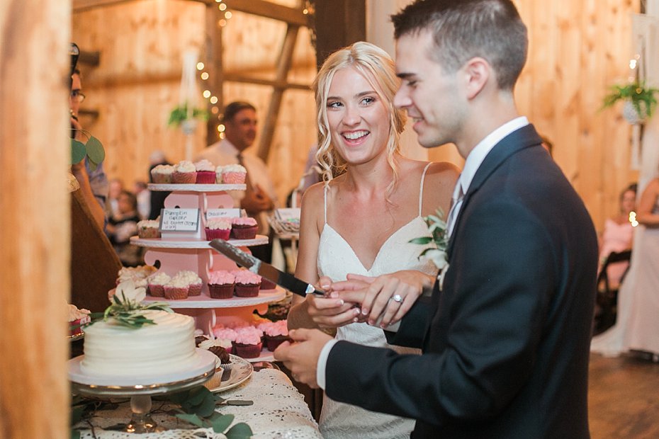 Bride and groom cut cake in the barn at White Chimneys wedding in Gap PA
