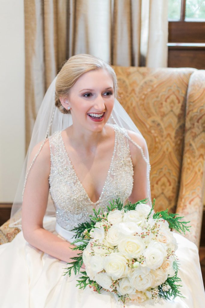 bride sitting in high back armchair with white bouquet at the Inn at Leola Village by the Jepsons