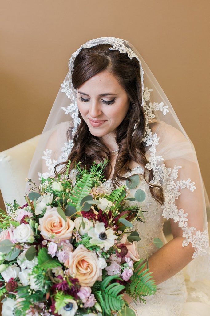 bride sits with bouquet by Pocketful of Posies in Zion Community Church in Bellefonte PA by the Jepsons