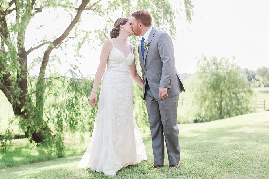 Bride and groom kiss by willow tree at Gillbrook Farms by the Jepsons