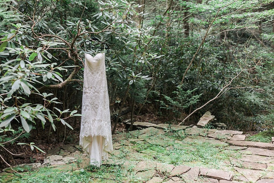 wedding dress by Formalities hanging on tree in the forest