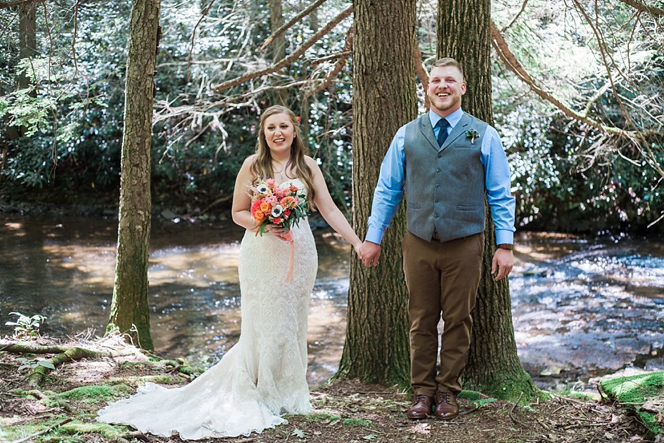 bride and groom posing by stream at Fern Hill Wedding