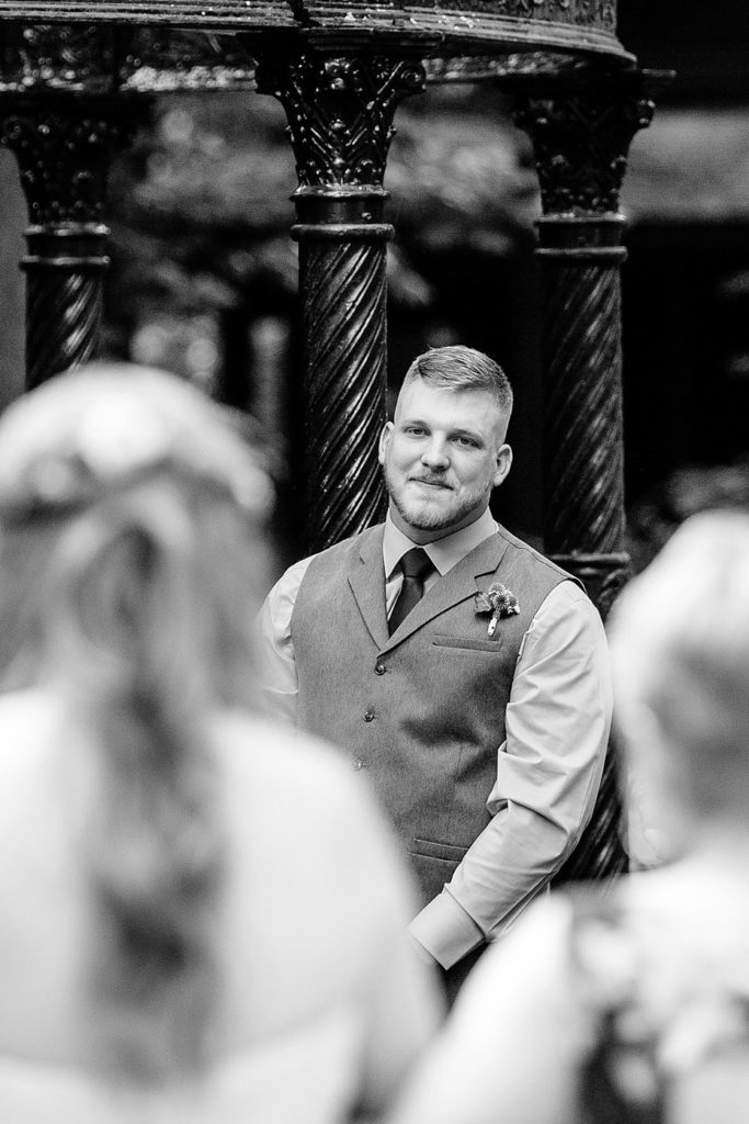 groom watches lovingly as bride walks down the aisle