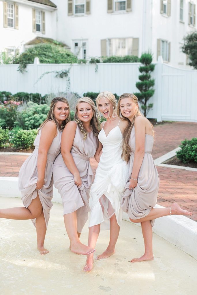 Bride and bridesmaids play in fountain at White Chimneys in Gap PA