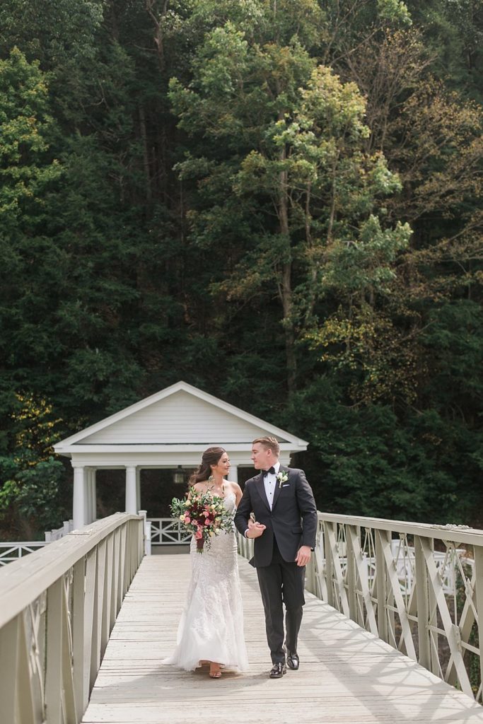 Bride and groom walk across the bridge at Omni Bedford Springs Resort