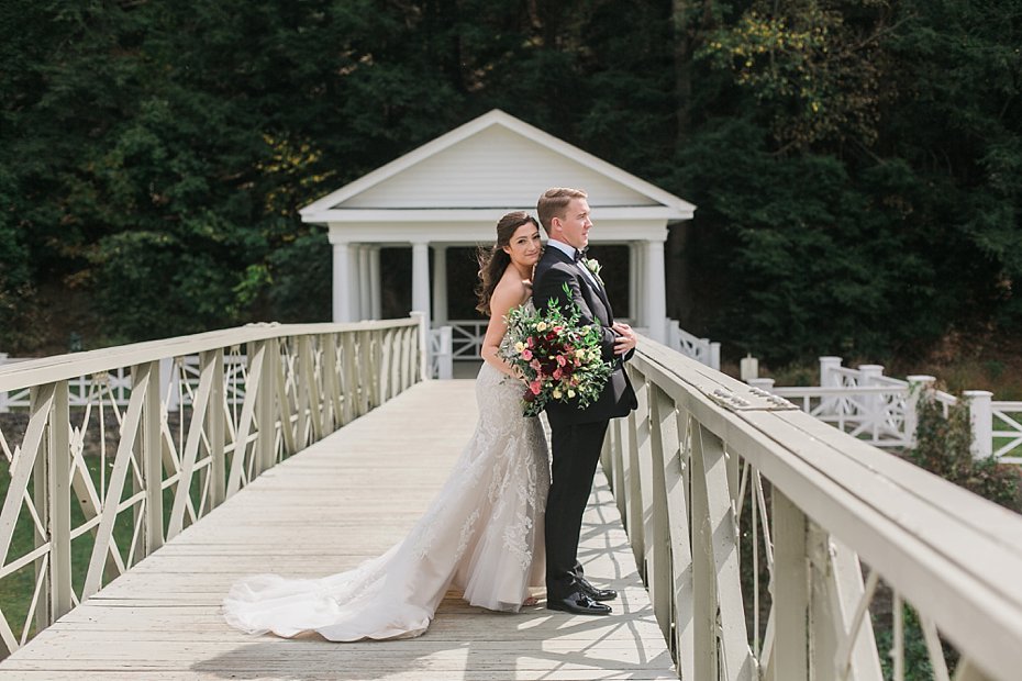 Bride and groom on walking bridge outside the Omni Bedford Springs Resort | things to consider before hiring a wedding photographer