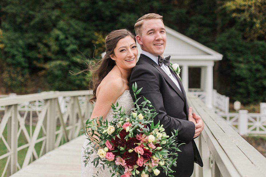 Bride and groom smile with florals by Country Blossoms Flowers at Omni Bedford Springs