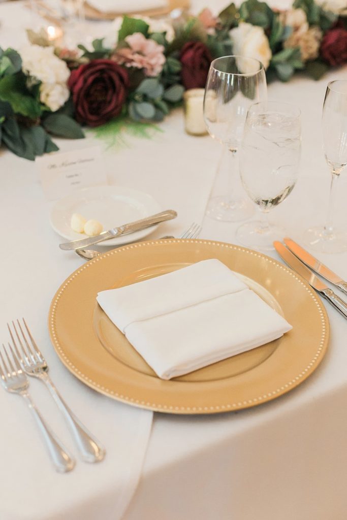 Gold and burgundy place settings at reception at Omni Bedford Springs