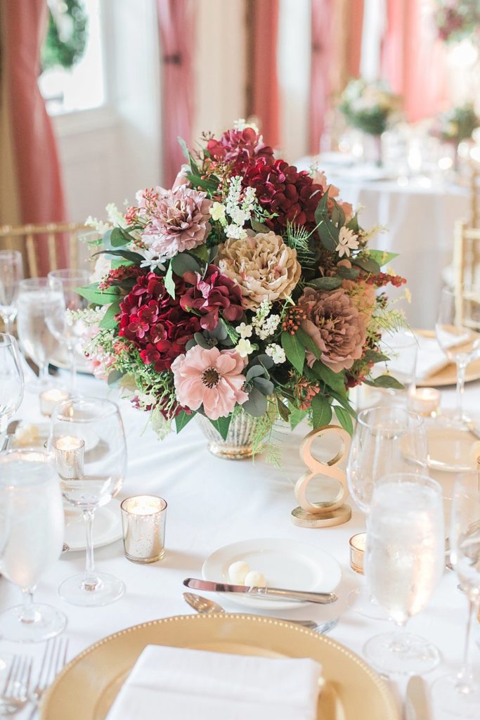 Burgundy and gold floral centerpieces by Country Blossoms Flowers and Gifts