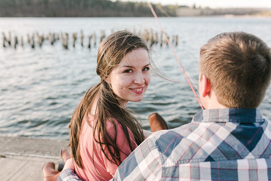 Couple sitting on lake pier in State College, PA during engagement session by the Jepsons