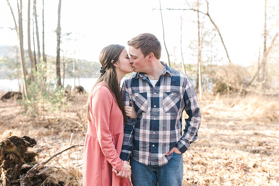 Couple kissing in woods by Colyer Lake in Central Pennsylvania