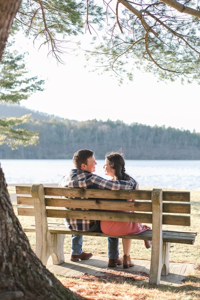 Couple sitting on Colyer Lake, PA bench for engagement session
