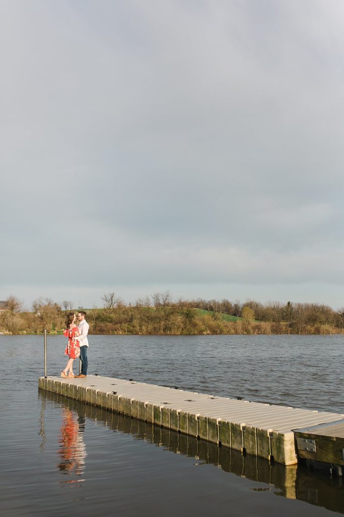 Couple embracing on pier at Speedwell Forge Lake in Pennsylvania.