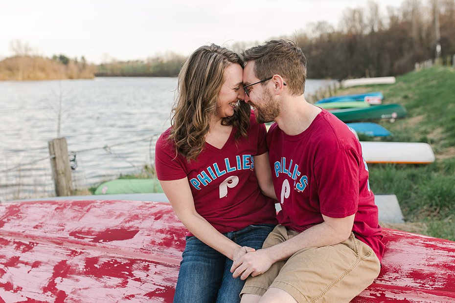 Engaged couple laugh on canoe at Speedwell Forge Lake by the Jepsons.