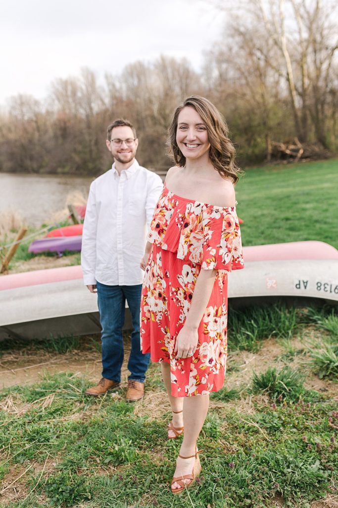 Couple poses by row of canoes on shores of Speedwell Forge Lake for engagement session by the Jepsons.