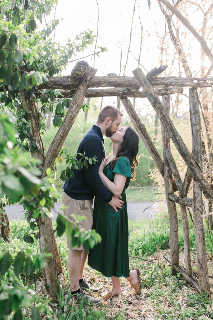 Engaged couple kissing under trellis in State College, PA